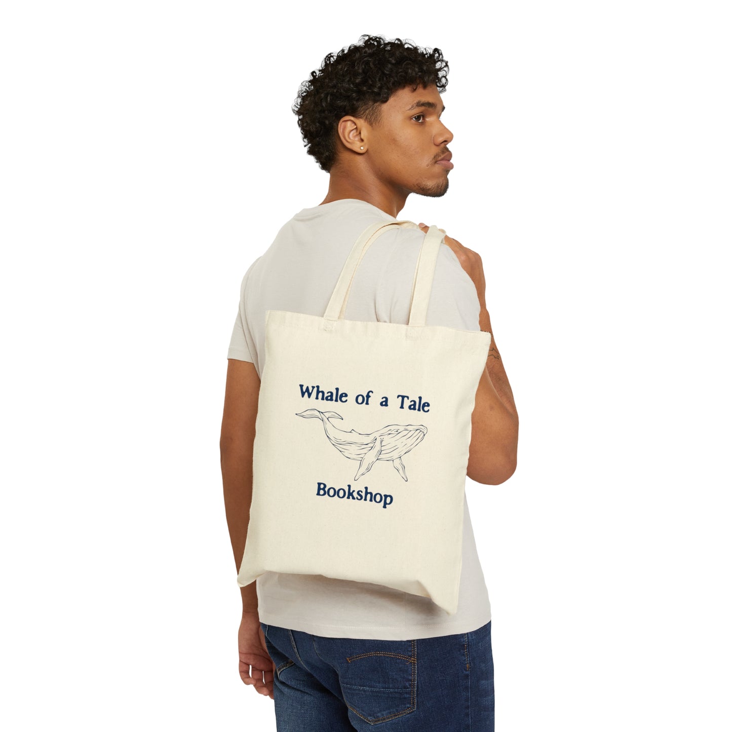 A canvas tote bag with a navy blue DTG graphic that features a whale and reads "Whale of a Tale Bookshop"