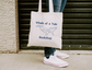 A canvas tote bag with a navy blue DTG graphic that features a whale and reads "Whale of a Tale Bookshop"