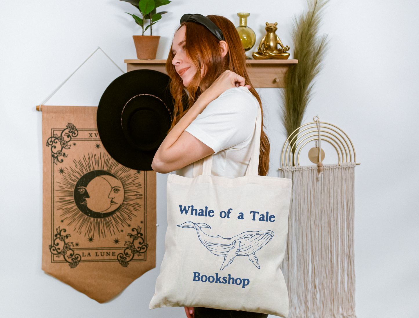 A canvas tote bag with a navy blue DTG graphic that features a whale and reads "Whale of a Tale Bookshop"