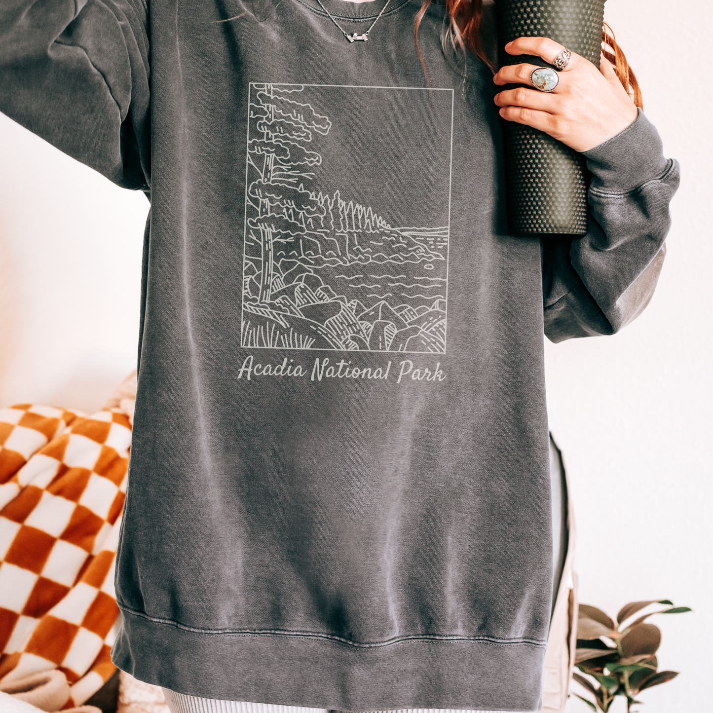 Comfort Colors 1566 Crewneck Sweatshirt with a white illustration graphic of a scene from Acadia National Park. The graphic reads "Acadia National Park" under the image.