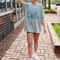 Woman wearing a chambray blue Comfort Colors t-shirt with a vintage-style North Carolina Tar Heel State graphic featuring a girl riding a bear through the mountains.