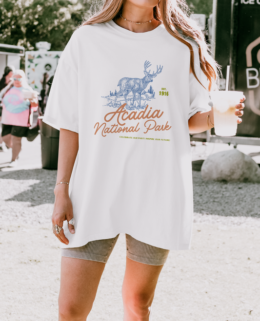 Woman wearing oversized Acadia National Park Comfort Colors 1717 t-shirt in white with moose graphic and vintage park text – relaxed outdoorsy aesthetic