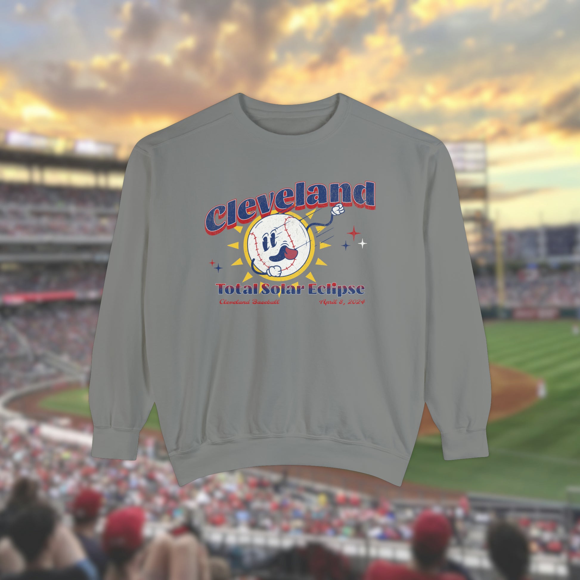 Grey Comfort Colors Crewneck Sweatshirt with a retro vintage inspired baseball character mascot. The text reads Cleveland Total Solar Eclipse CLE baseball April 2024