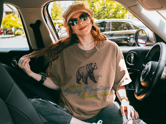 Woman sitting in a car wearing Great Smoky Mountains National Park t-shirt with vintage bear graphic – Comfort Colors 1717 in espresso. granola girl aesthetic