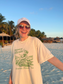 Woman wearing vintage-style Florida Everglades National Park graphic tee on a beach at sunset – relaxed fit Comfort Colors shirt with granola girl aesthetic.