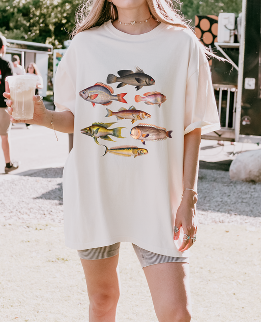 Model wearing a Graphic t-shirt featuring colorful vintage fish illustrations on a Comfort Colors tee, perfect for coastal and fisherman aesthetics.